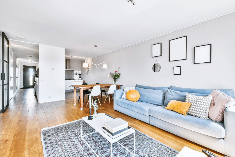 Inflace a nemovitosti: Světle laděný obývák s modrou sedačkou v bytě nebo domě.